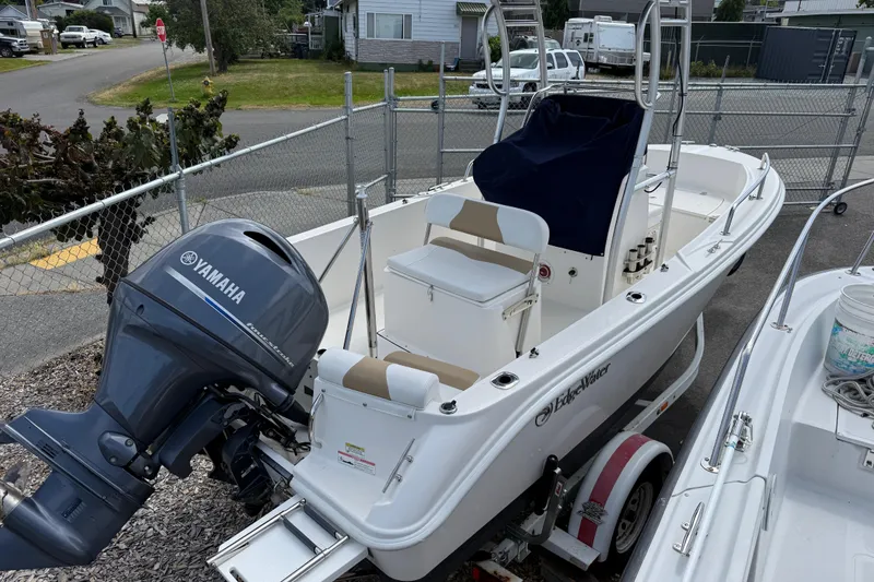 Slide: The Image of 2015 Edgewater 170CC boat with Yamaha outboard motor on a trailer in a fenced area. - 10