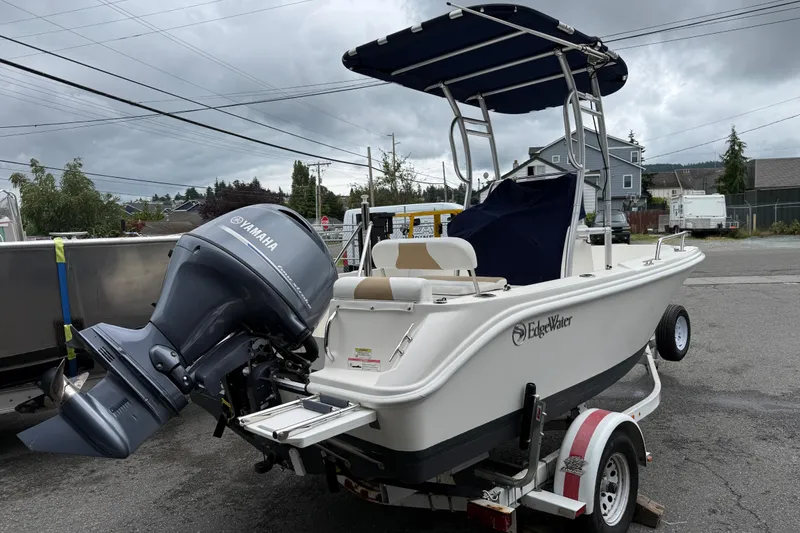 Slide: The Image of 2015 Edgewater 170CC boat with Yamaha outboard motor on a trailer, parked outdoors. - 2