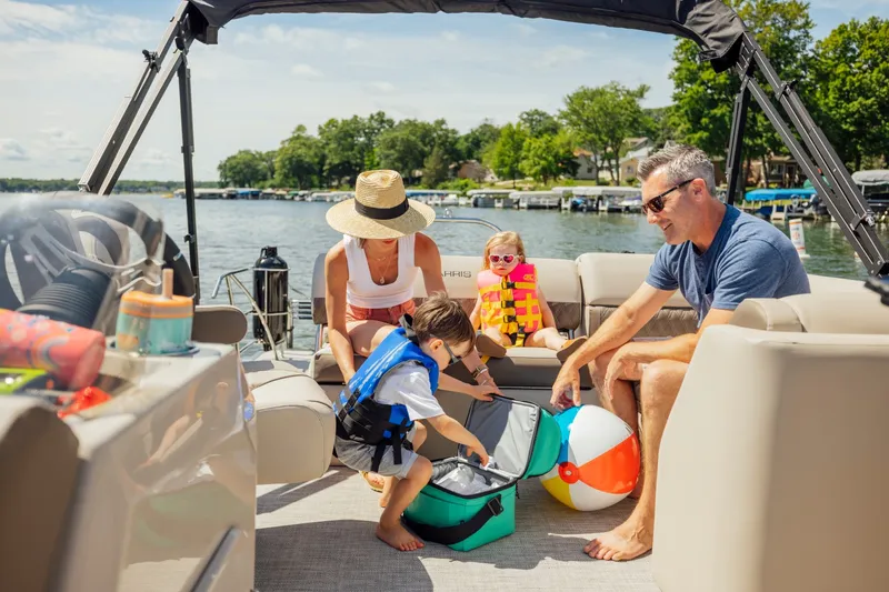 Slide: The Image of Family enjoying a day on a Harris 210SL pontoon boat on a lake. - 33