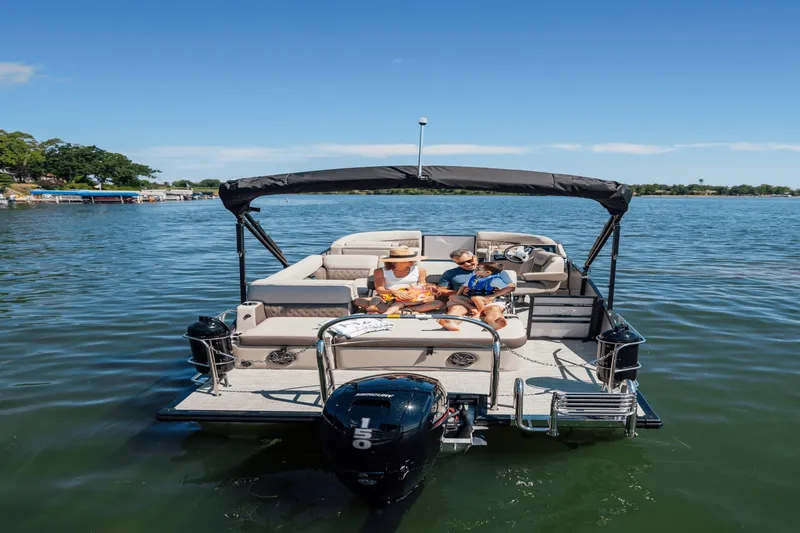 Slide: The Image of Two people relax on a Harris 210SL pontoon boat on a calm lake. - 36