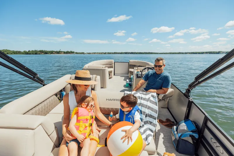 Slide: The Image of A family enjoys a boat ride on a Harris 210SL. They relax and play with a ball. - 35