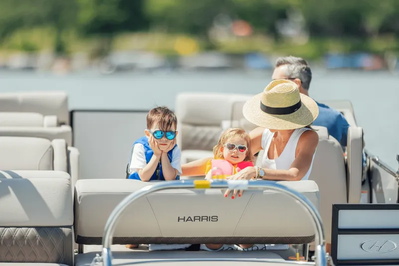 Slide: The Image of Family enjoying a boat ride on a Harris 210SL pontoon boat. - 14