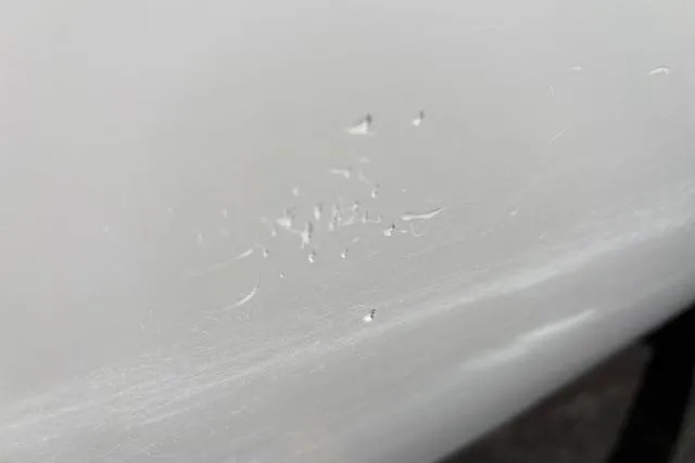 Slide: The Image of Close-up of paint imperfections on a 2024 Tahoe T21 vehicle surface. - 22