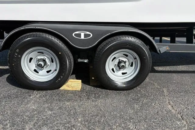 Slide: The Image of 2024 Tahoe T21 trailer wheels on asphalt with wooden block support. - 32