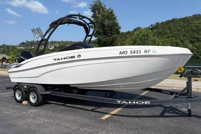Slide: The Image of 2024 Tahoe T21 boat on trailer, parked outdoors with scenic background. - 1