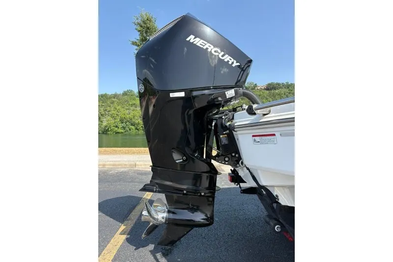 Slide: The Image of 2024 Tahoe T21 boat with Mercury outboard motor, parked near a scenic lake. - 27