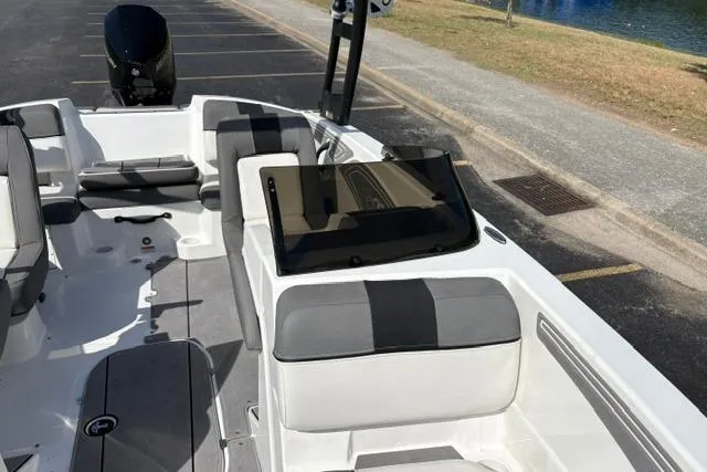 Slide: The Image of 2024 Tahoe T21 boat interior with gray and white seating, parked near water. - 9
