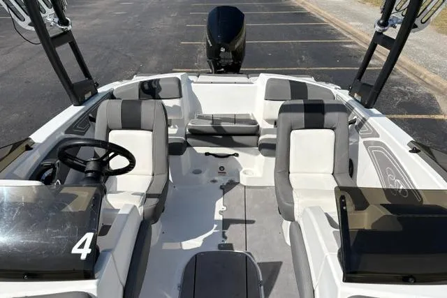 Slide: The Image of 2024 Tahoe T21 boat interior with gray and white seating, steering wheel, and open deck layout. - 11