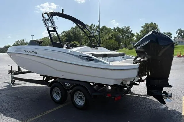 Slide: The Image of 2024 Tahoe T21 boat on trailer with Mercury outboard motor, parked outdoors. - 4