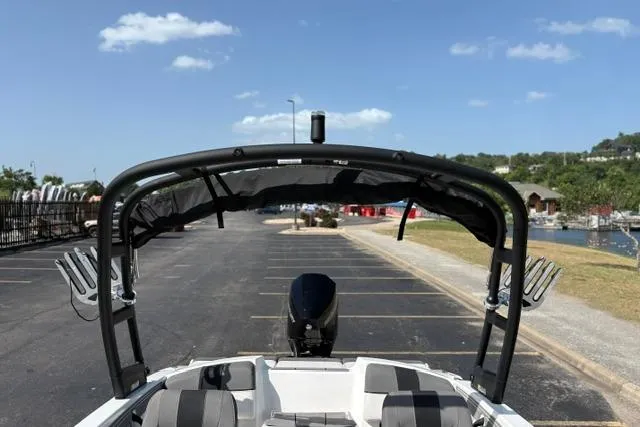 Slide: The Image of 2024 Tahoe T21 boat with canopy, parked near a marina under a clear blue sky. - 18