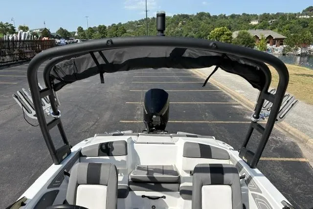 Slide: The Image of 2024 Tahoe T21 boat with seating and canopy, parked in a lot near a scenic area. - 12
