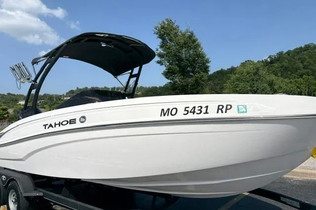 Slide: The Image of 2024 Tahoe T21 boat on trailer, white hull, black canopy, parked outdoors. - 5