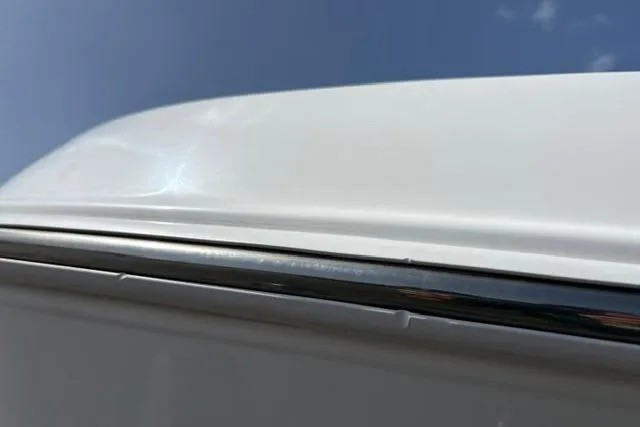 Slide: The Image of 2024 Tahoe T21 vehicle roof detail with chrome trim against blue sky. - 24