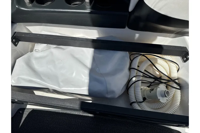 Slide: The Image of Storage compartment in a 2015 Axis A20 boat with coiled hose and cover. - 29