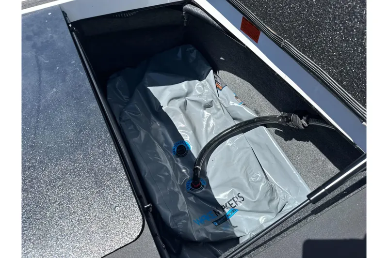 Slide: The Image of 2015 Axis A20 boat storage compartment with ballast bag and hose. - 26