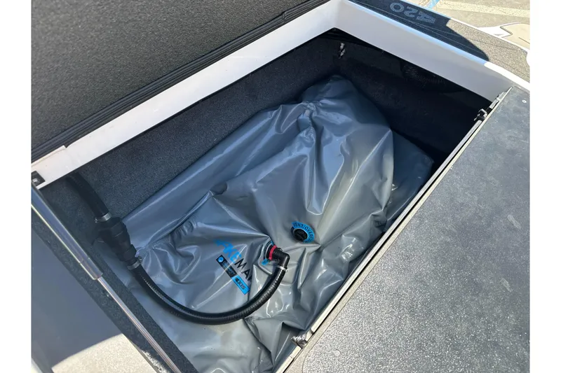 Slide: The Image of 2015 Axis A20 boat ballast compartment with gray ballast bag and hose connection. - 27