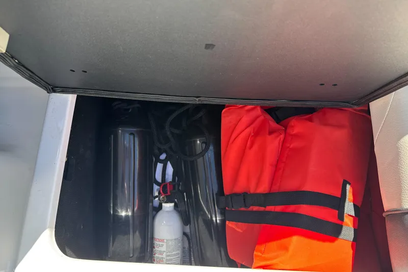 Slide: The Image of Storage compartment in a 2015 Axis A20 boat with life jacket and fire extinguisher. - 23