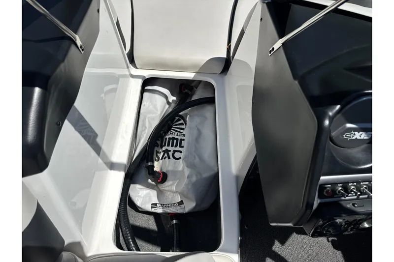 Slide: The Image of 2015 Axis A20 boat interior storage compartment with ballast bag and hose. - 28