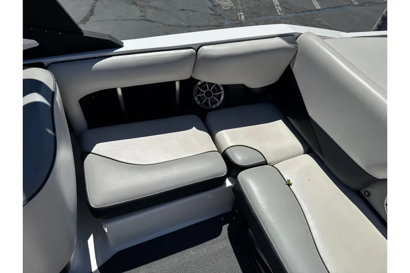 Slide: The Image of Interior seating of a 2015 Axis A20 boat, featuring gray upholstery and a speaker. - 20