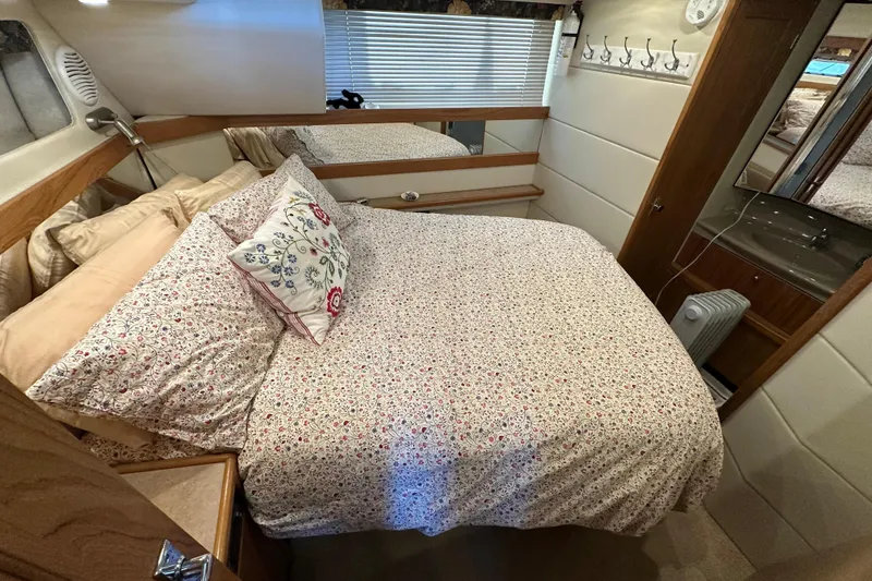 Slide: The Image of Cozy bedroom in 2000 Bayliner 4087 Aft Cabin Motoryacht with floral bedding and wooden accents. - 22