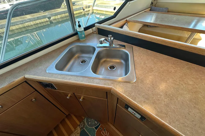 Slide: The Image of Kitchen sink area in 2000 Bayliner 4087 Aft Cabin Motoryacht with countertop and window view. - 21