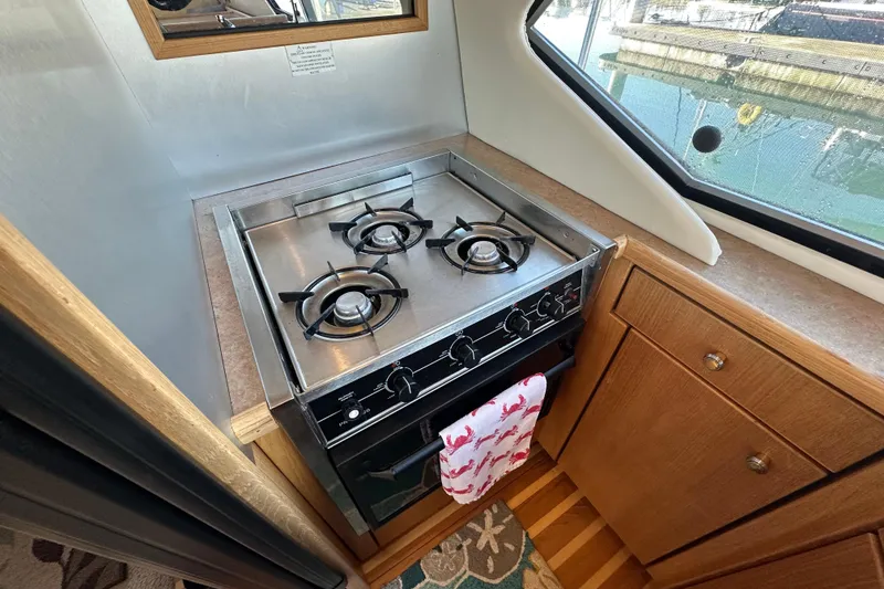 Slide: The Image of Compact kitchen area in a 2000 Bayliner 4087 Aft Cabin Motoryacht with a three-burner stove. - 20