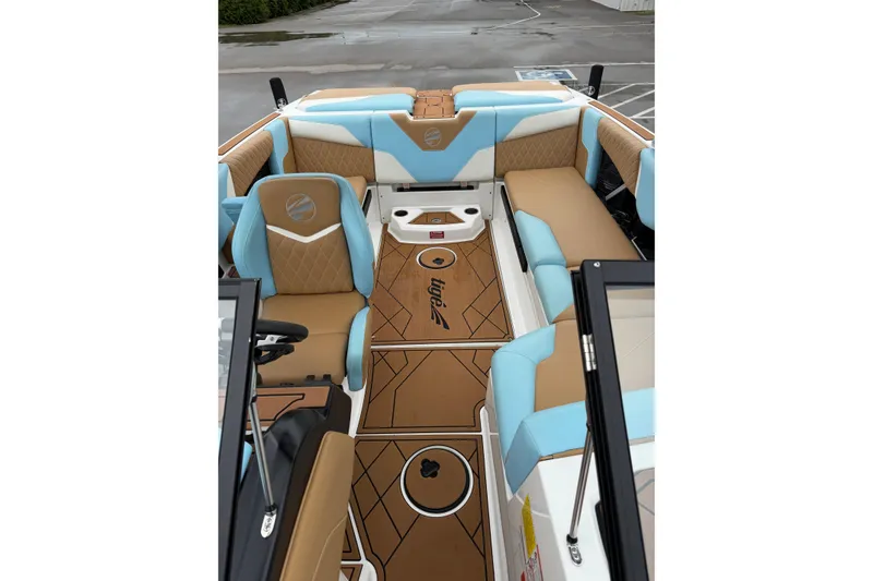 Slide: The Image of 2023 Tigé Z1 boat interior with tan and blue seating, stylish design, and branded flooring. - 9
