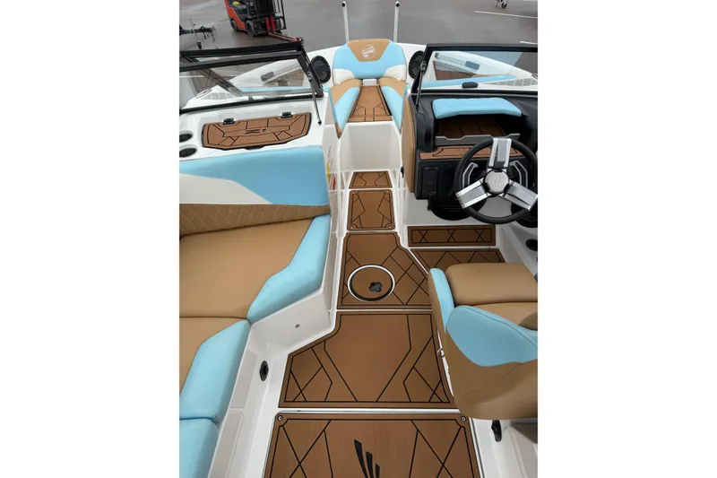 Slide: The Image of 2023 Tigé Z1 boat interior with brown and blue seating, modern steering wheel, and geometric flooring. - 6