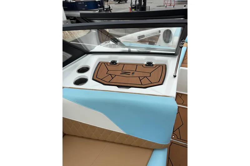 Slide: The Image of 2023 Tigé Z1 boat interior with blue and tan upholstery, cup holders, and sleek dashboard design. - 8