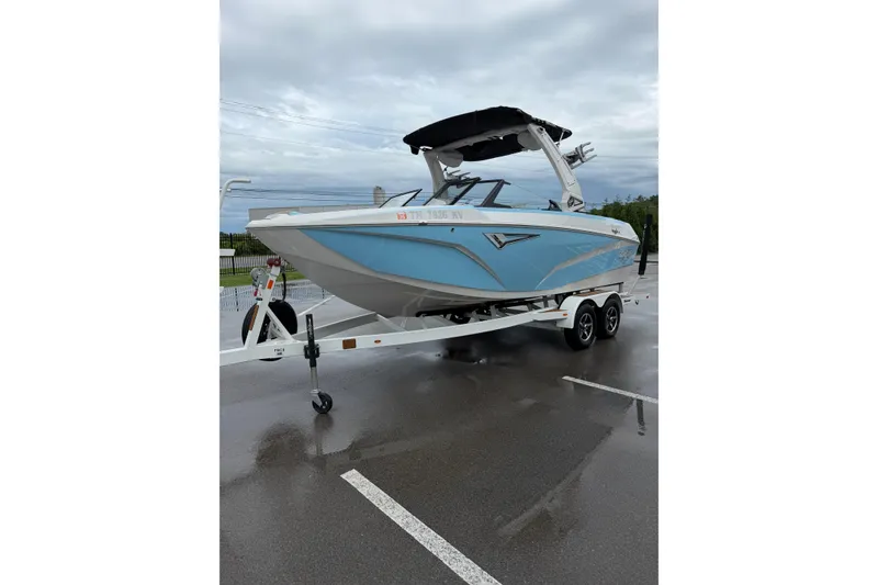 Slide: The Image of 2023 Tigé Z1 boat on trailer in parking lot, featuring sleek blue design. - 4