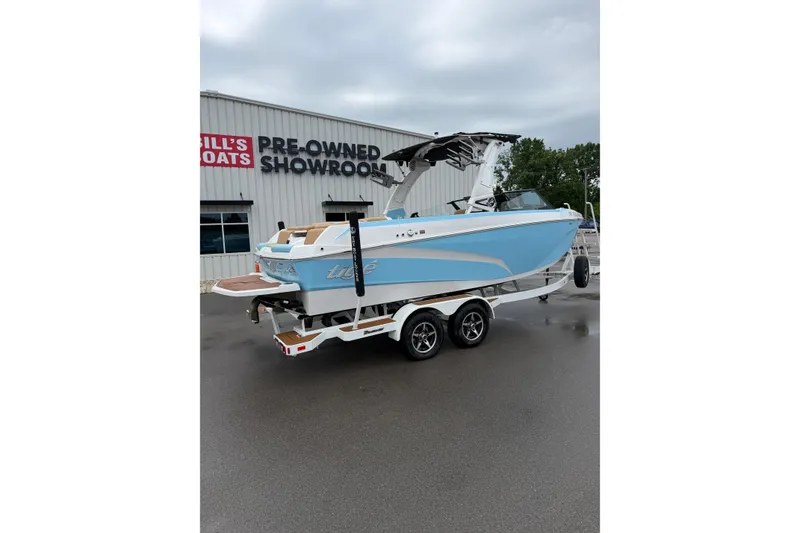 Slide: The Image of 2023 Tigé Z1 boat on trailer outside pre-owned showroom. - 1