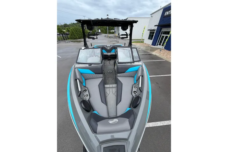 Slide: The Image of 2023 Tigé Z1 boat with sleek gray and blue interior, parked outdoors. - 2