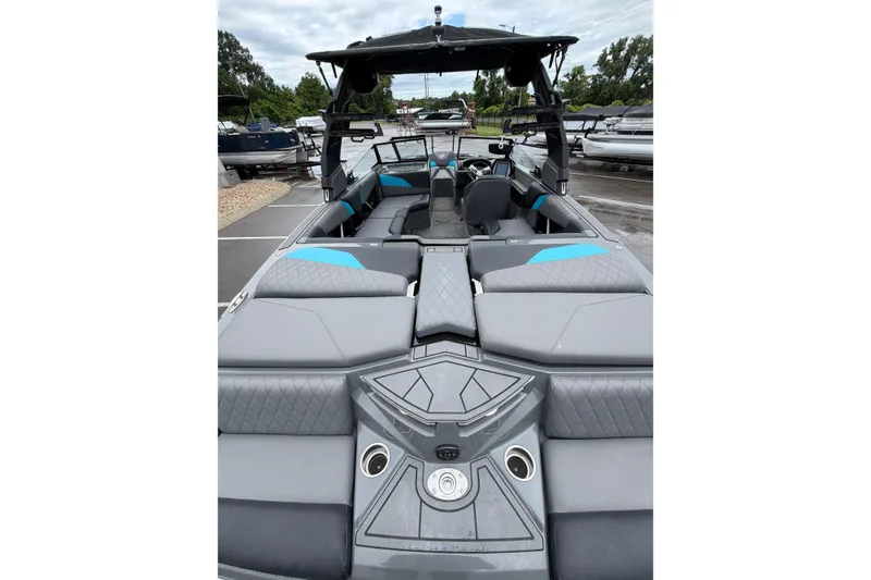 Slide: The Image of 2023 Tigé Z1 boat interior with sleek gray and blue seating, docked outdoors. - 6