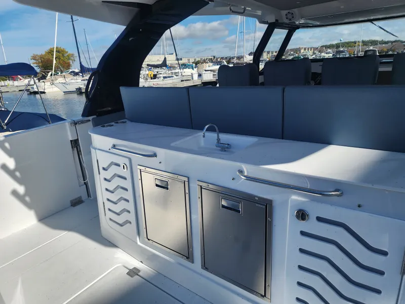Slide: The Image of The 2027 Cruisers Yachts 45VTR features a modern outdoor kitchen with a sink and storage. - 23