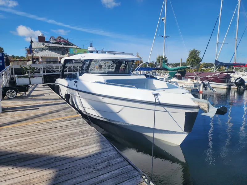 The Image of A modern white yacht docked at a wooden pier in a bustling marina. - 0