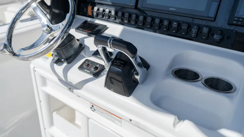 Slide: The Image of The image shows the helm of a Sea Hunt Gamefish 25 boat with steering wheel and controls. - 21