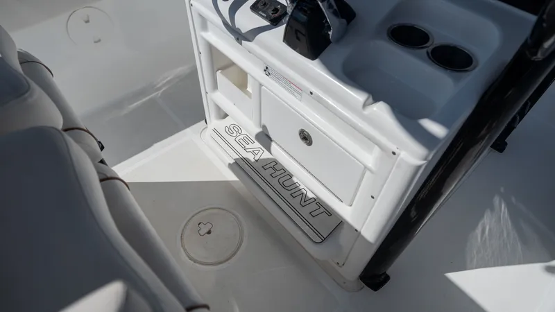 Slide: The Image of The image shows the helm area of a 2020 Sea Hunt Gamefish 25 boat with cup holders and storage. - 22