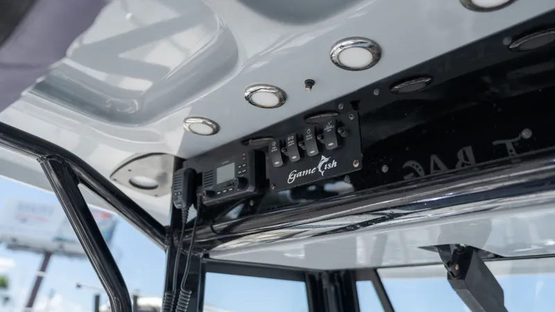 Slide: The Image of The image shows the helm of a Sea Hunt Gamefish 25 boat with switches and lights. - 16