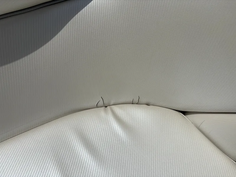 Slide: The Image of Close-up of a white boat seat with small tears in the upholstery. - 19