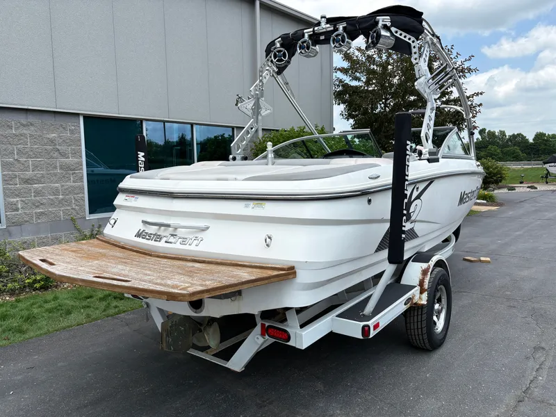 Slide: The Image of A white 2011 MasterCraft X2 boat on a trailer in front of a building. - 6