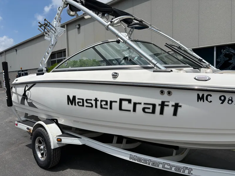 Slide: The Image of A white 2011 MasterCraft X2 boat on a trailer in front of a building. - 3