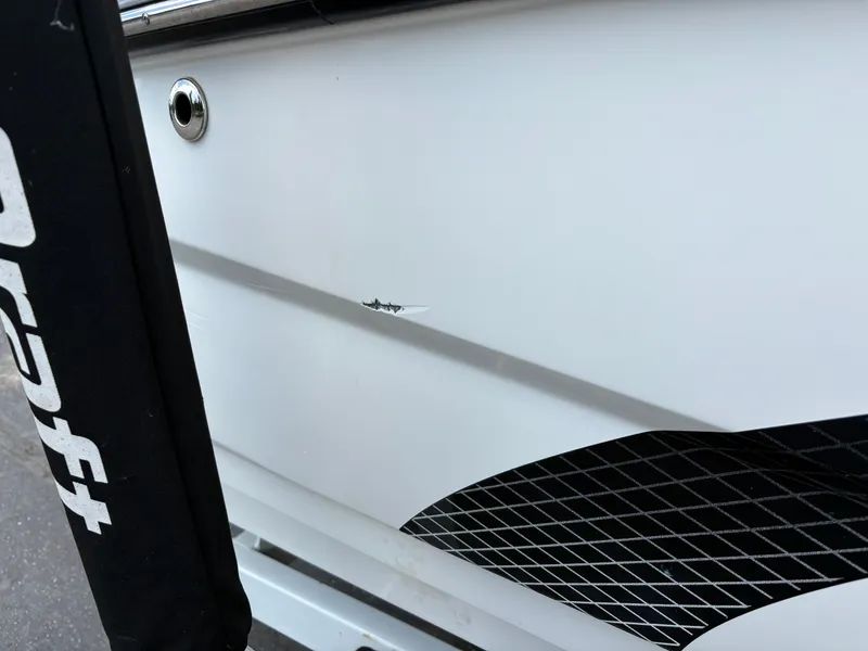 Slide: The Image of Close-up of a white boat hull with a small scratch and black grid pattern. - 4
