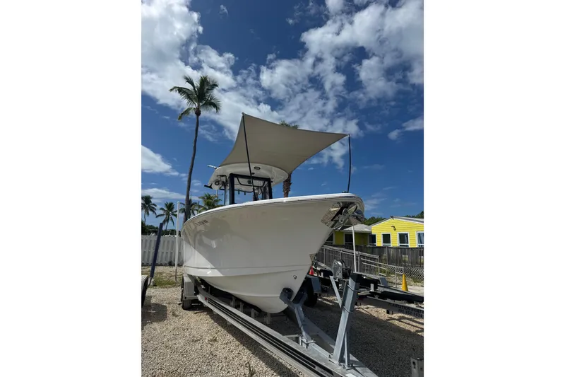 Slide: The Image of 2019 Sea Hunt Gamefish 27 Coffin Box boat on trailer under blue sky with palm trees. - 40