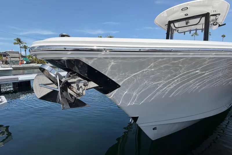 Slide: The Image of 2019 Sea Hunt Gamefish 27 Coffin Box boat docked, showcasing sleek hull design and anchor. - 6