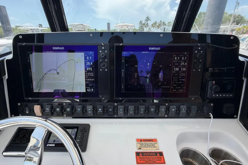 Slide: The Image of 2019 Sea Hunt Gamefish 27 dashboard with dual Simrad displays and control panel. - 29