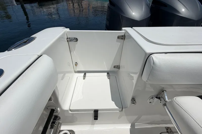 Slide: The Image of 2019 Sea Hunt Gamefish 27 Coffin Box interior, featuring sleek white seating and storage. - 20