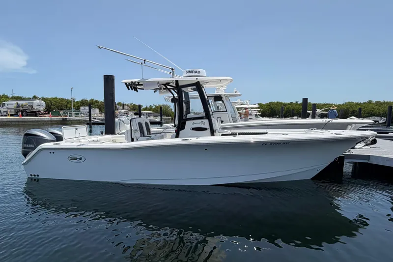 Slide: The Image of 2019 Sea Hunt Gamefish 27 Coffin Box boat docked in marina, clear sky background. - 3