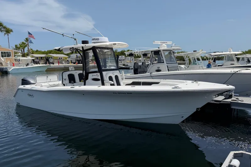 Slide: The Image of 2019 Sea Hunt Gamefish 27 Coffin Box boat docked in marina, clear sky background. - 2