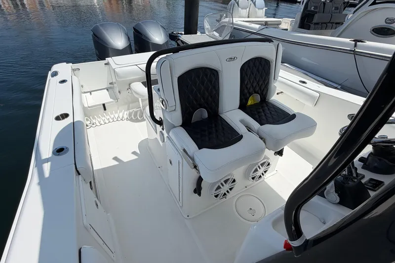 Slide: The Image of 2019 Sea Hunt Gamefish 27 Coffin Box boat interior with dual seats and twin engines. - 17