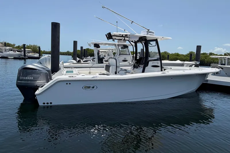 Slide: The Image of 2019 Sea Hunt Gamefish 27 Coffin Box boat docked, featuring Yamaha engines. - 4